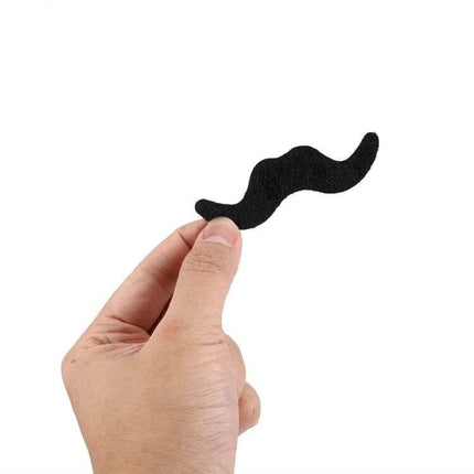 12-In-1 Funny Halloween Mustache Kit for Trick or Treat showing hand holding a black adhesive mustache for quick costume changes