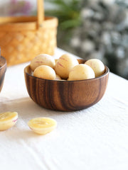 Handcrafted acacia wood bowl filled with fresh fruit for an elegant table setting