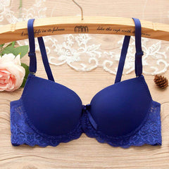 Underwire gathered bra for small bust with lace and bow details in navy blue, displayed on a hanger with floral decorations