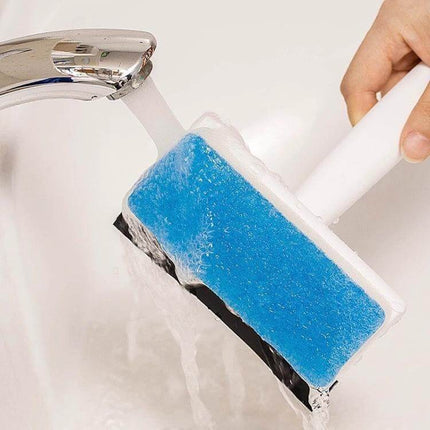 2-In-1 Window Glass Cleaning Brush With Dust Collecting held under faucet, blue sponge creating foam and rubber scraper visible