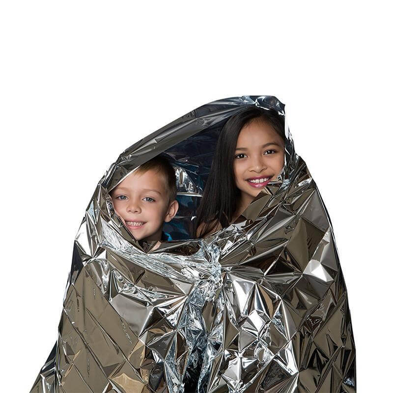 Kids using a hypothermia protection blanket for warmth and safety in outdoor survival situations.