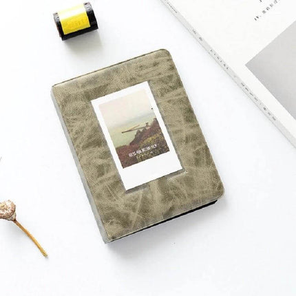 3-Inch PU Cover Photo Album for Keepsakes, Colorful Starry Series green PU cover on white desk with sample 3-inch photo and travel props