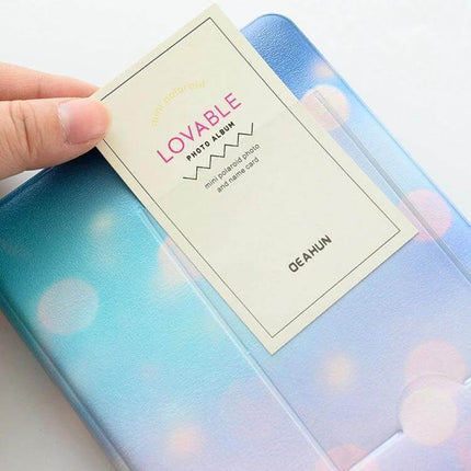 3-Inch PU Cover Photo Album for Keepsakes, Colorful Starry Series showing blue-purple PU pocket album with a hand inserting a 3-inch photo card
