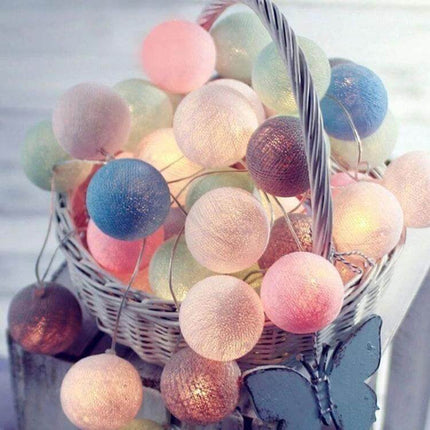 3M Cotton Ball String Lights For Holiday Decor 20 LEDs - pastel cotton ball LED string draped in white wicker basket, soft warm decorative lighting