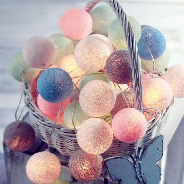 3M Cotton Ball String Lights For Holiday Decor 20 LEDs - pastel cotton ball LED string draped in white wicker basket, soft warm decorative lighting