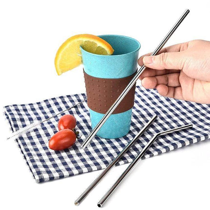 4 Pack Reusable Stainless Steel Drinking Straws With Cleaning Brush Kit Straight - hand holding straw next to blue cup with lemon, stainless steel straws on cloth