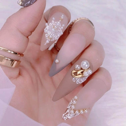 5D Rose Pattern Embossed Nail Art Stickers For Easy Manicure applied on long nude matte stiletto nails with pearls and gold accents