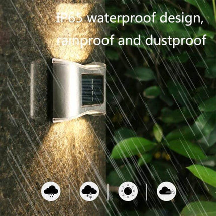 6 LED Solar Outdoor Garden Wall Lamp, Stainless Steel mounted on exterior wall in rain demonstrating IP65 waterproof design and warm walkway illumination