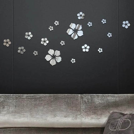 Acrylic Cherry Blossom Wall Mirror Sticker 18-Piece Set displayed above a sofa, silver 3D floral mirror decals on dark wall
