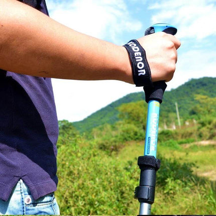 Adjustable Outdoor Trekking Poles for Hiking, Aluminum, 107-125 cm in use with wrist strap and adjustable aluminum shaft on grassy trail