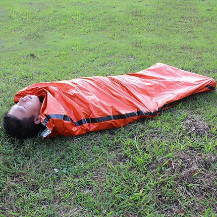Aotu Orange First Aid Sleeping Bag for Outdoor Camping on grass, aluminized emergency thermal blanket, high-visibility orange rescue sleeping bag