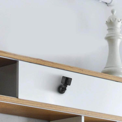 CAMSOY S1 Wireless WiFi Surveillance Camera for Home Monitoring mounted on shelf corner showing compact wireless camera with motion detection