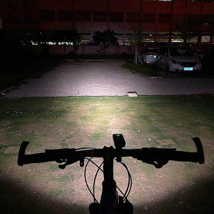 BX3 USB Charging Bicycle Front Handlebar Light for Night Riding illuminating a bike path from handlebar view with focused white beam