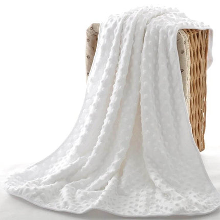 Baby Double Layer Knitted Fleece Blanket For Cozy Snuggles white textured baby blanket draped over wicker basket