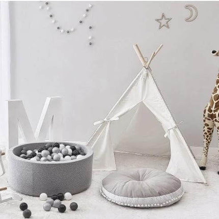 Baby Bean Bag Chair Portable Foldable For Feeding And Naps gray round cushion in neutral nursery with teepee and ball pit