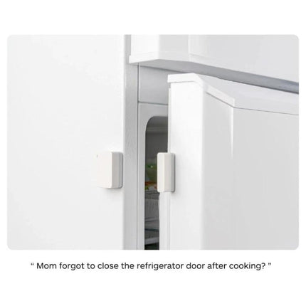 Xiaomi Intelligent Mini Door and Window Sensor for Home Security mounted on a refrigerator door providing open/close alerts