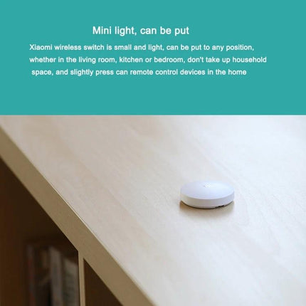 Xiaomi Intelligent Mini Wireless Switch for Smart Home Control on a tabletop showing compact wireless button for lights and devices