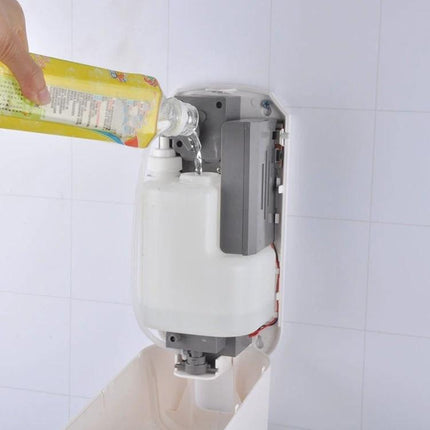 Automatic Touch-Free Dispenser for Daily Home Sanitizing Routines being refilled with sanitizer bottle inside wall-mounted unit