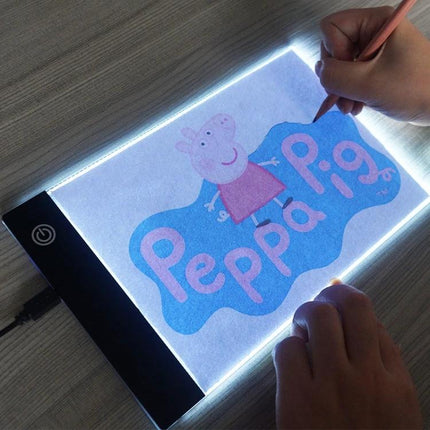 A5 Acrylic Sketch Board for Drawing and Tracing lit LED tracing tablet showing hands tracing a Peppa Pig print