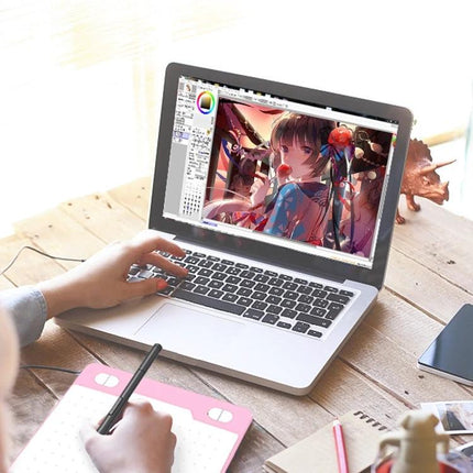 10Moons Drawing Tablet for Mobile and Tablet Devices showing sketching on a laptop with stylus and USB-connected tablet