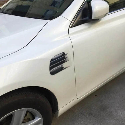 Adhesive Fake Vent Decorative Stickers for Car Surfaces applied on white car door near front wheel, black vent-style decal for exterior customization