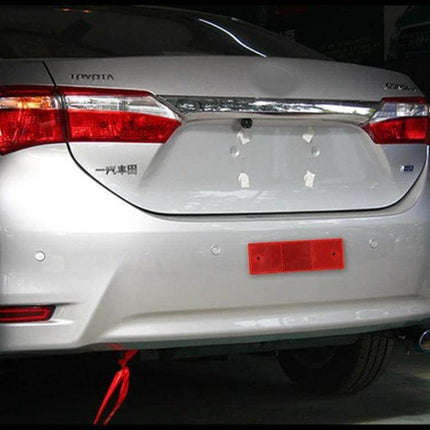 Set of 10 Car Rear Bumper Plastic Warning Reflectors for Safety - red reflector strip mounted on white sedan rear bumper for added visibility