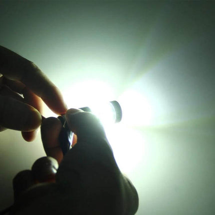 Dual Color LED Car Brake and Turn Signal Light For 12V showing hands holding a bright white LED bulb during installation