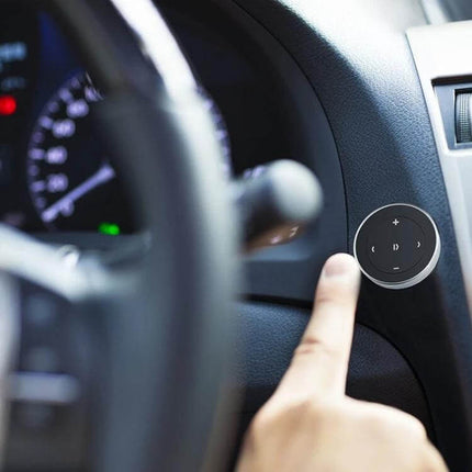 Car Wireless Bluetooth Steering Wheel Remote Controller With Holder mounted on car dash showing thumb pressing media control button