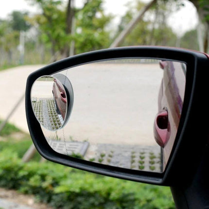 Wide Angle Adjustable Oval Blind Spot Mirror for Vehicles mounted on car side mirror showing expanded rear view for safer lane changes