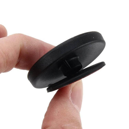 Wide Angle Blind Spot Mirrors for Cars and Trucks, 2 Pack - close-up of black round adhesive-mounted blind spot mirror backing held between fingers