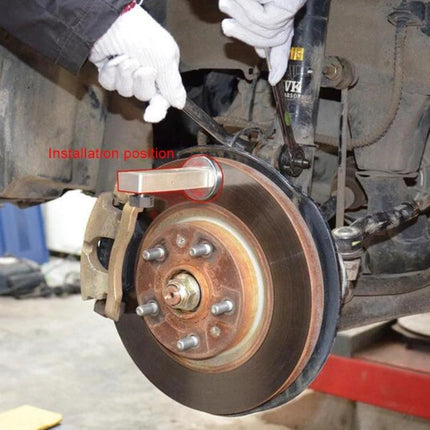 Essential Tool for Home Car Wheel Alignment Checks - mechanic attaching camber caster gauge to hub and brake disc for at-home alignment verification