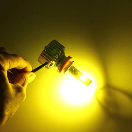 Two Pack Car LED Headlight Bulbs For DRL And Night Driving - illuminated COB CANBUS LED bulb shown handheld emitting bright yellow DRL beam