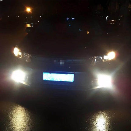 Car Fog Lights White LED 2-Pack For All-Weather Driving — front view of car at night with bright white LED fog lights installed, P13W plug-and-play upgrade