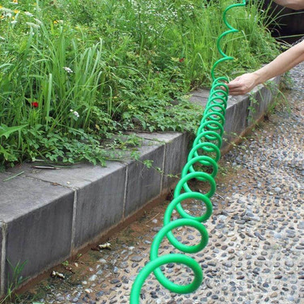 Garden Watering Telescopic Hose 30m With Connector coiled green spiral hose being extended along garden border