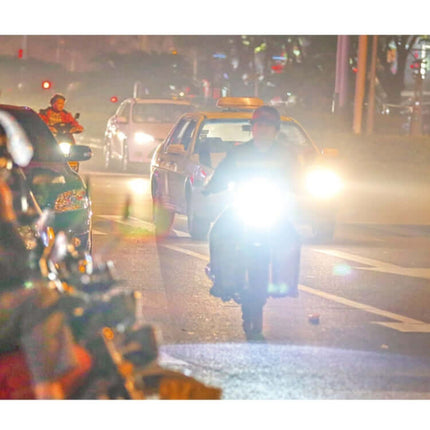 High-Intensity LED Motorcycle Headlight for Night Visibility on a scooter riding at night with bright beam illuminating dark road