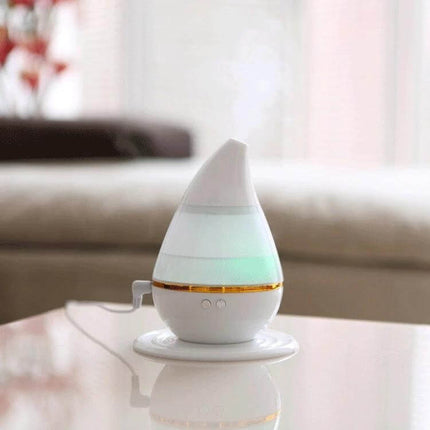 Ultrasonic USB Humidifier Purifier With Aroma Atomizer on a table emitting mist and soft night light, USB-powered compact aroma diffuser