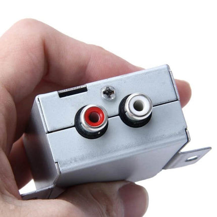 RCA Noise Filter Loop Isolator for Car Audio Stereos in hand showing red and white RCA inputs, aluminum shell to reduce ground-loop hum