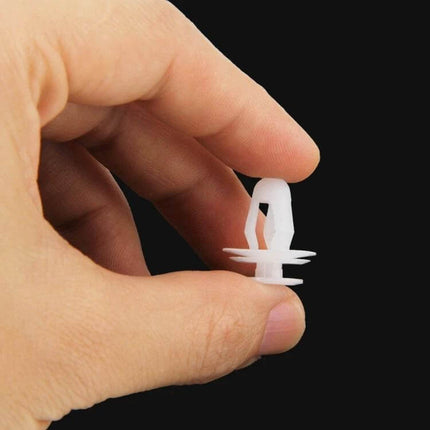 Universal Car Door Panel Replacement Clips, 100-Piece Set - close-up hand holding single white plastic door panel clip for vehicle interior repair