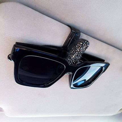 Compact Diamond Mounted Car Glasses and Bill Clip Holder in Mixed Colors on car visor holding black sunglasses and bills, plastic organizer with rhinestone detail