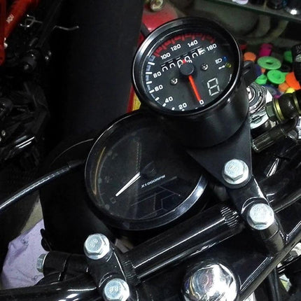 Universal Waterproof 3-in-1 Motorcycle Speedometer and Odometer mounted on motorcycle handlebars showing speed dial and LED display