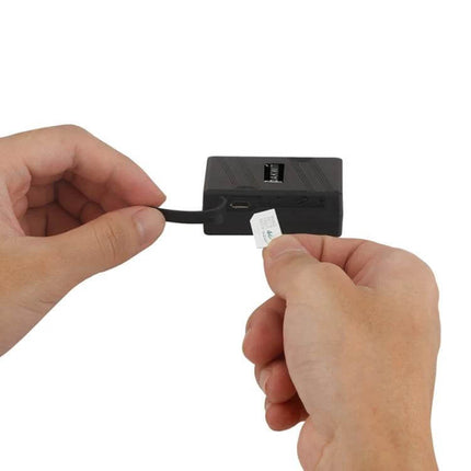 Strong Magnetic GPS Tracker for Real-Time Vehicle Monitoring - hands inserting SIM card and charging cable into compact tracker
