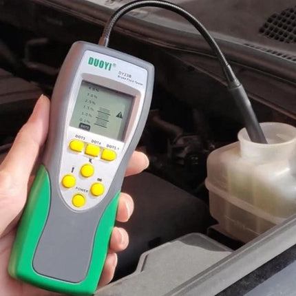 DUOYI Tool for Routine Car Fluid Maintenance Checks handheld brake fluid tester showing probe dipped into brake reservoir for water-content check