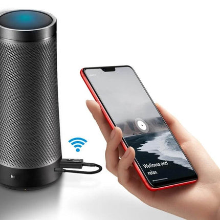 Car Bluetooth Transmitter Receiver With Microphone plugged into speaker with hand holding smartphone for wireless music streaming and hands-free calls