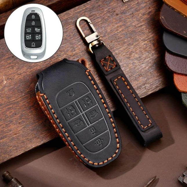 Hallmo Cowhide Leather Key Case for Hyundai 7-Button Keys in black with orange stitching shown on wooden surface, includes leather strap and key fob