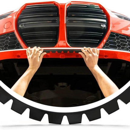 Black Car Bumper Guard Kit for Scratch and Scuff Protection installed on red car front bumper being fitted by hands