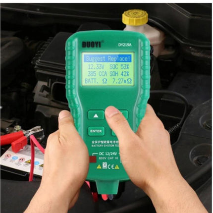 DUOYI Device for Routine Car Battery Checks in Daily Maintenance showing hands-held green battery tester displaying voltage and health readings