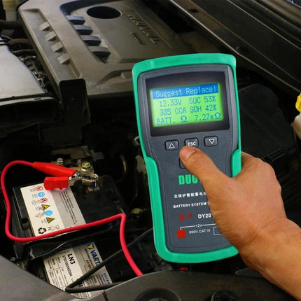 DUOYI Tool for Daily Car Battery Maintenance Checks showing a handheld battery tester connected to a car battery reading 'Suggest Replace'
