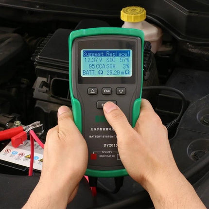 DUOYI Car Battery Tester for Everyday Vehicle Checks showing hands operating handheld tester on a car battery in engine bay