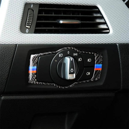 BMW Carbon Fiber Headlight Switch Decorative Sticker installed on BMW dashboard showing carbon fiber trim with M stripe around headlight switch