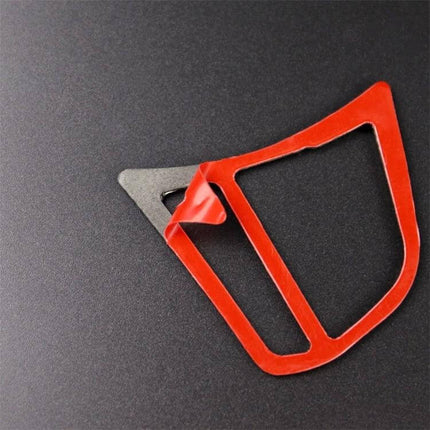 Carbon Fiber Decorative Sticker for BMW Steering Wheels on black background showing red peel-back protective film